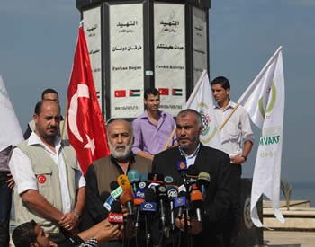 Muhammad Kaya (center) holds a press conference at the monument erected by Hamas for the 