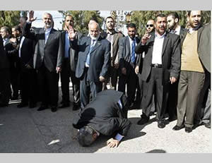 Khaled Mashal besa la tierra de Gaza en el momento de su entrada  en la Franja desde el pasaje Rafiah. ( foro Hamás, 7 de diciembre de 2012). 