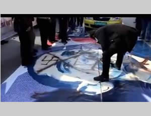 Palestinian demonstrators in Bethlehem walk on a picture of President Obama defaced with a swastika.