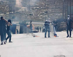 Palestinian youths set fire to an Israeli flag during a violent confrontation with IDF forces in Hebron 