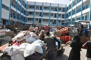 Des résidents du Nord de la bande de Gaza exécutent l'appel de Tsahal à évacuer et trouvent refuge dans les écoles de l'UNWRA dans le camp de réfugiés d'Al-Shati dans la ville de Gaza (Paltoday, 13 juillet 2014)