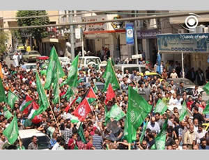 The funeral held in Hebron for the two terrorists. Participants hold green Hamas-affiliated and red and white Popular Front for the Liberation of Palestine (PFLP) flags