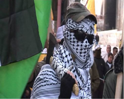 A masked terrorist operative holds an axe at a Fatah rally (PNN.ps, January 2, 2015).