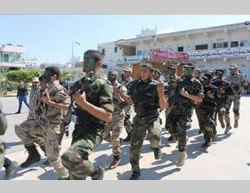 Alumnos del programa al Fatuah vestidos con uniforme y llevando armas.