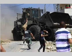 Palestinos arrojan piedras hacia las fuerzas de seguridad israelíes en Kfar Qadoum durante la manifestación semanal (página facebook de Kfar Qadoum, 26 de junio de 2015)