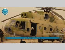 Al-Nusra Front operatives next to a Syrian helicopter at the Abu al-Duhur military airbase.  