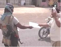 Armed ISIS operatives distributing leaflets to residents of Aden explaining the rules of conduct in the Islamic State.