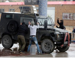 Palestinians attack an Israeli security vehicle with stones in the village of Nebi Saleh (Wafa, March 3, 2017). 