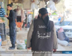 An operative of Al-Hisba (ISIS’s morality police) observing an open market (Haqq, May 15, 2017). 