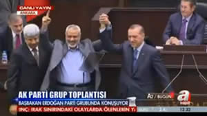 Ismail Haniya waves to the Turkish parliament while holding hands with Tayyip Erdogan (YouTube.com)