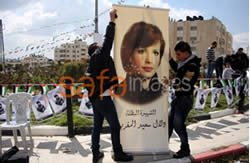 Fatah activists in Ramallah hang a picture of terrorist Dalal al-Magribi, who participated