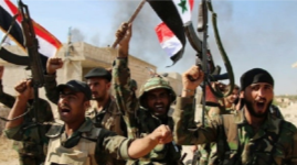 Syrian army soldiers wave Syrian flags and rifles after taking control of Deir al-Zor. 