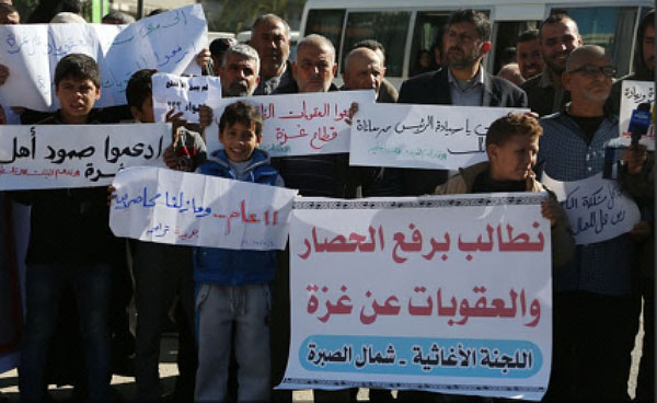 Gazans demonstrate in front of the government's offices demanding the sanctions imposed on the Gaza Strip be lifted immediately (Palinfo Twitter account, December 4, 2017).