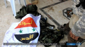 The flag of the Palestinian Al-Quds Brigade near a vest, found by ISIS (Akhbar Al-Muslimeen, January 17, 2018)