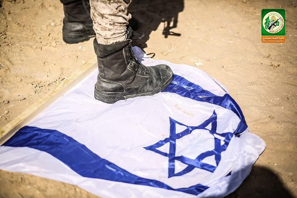 Stepping on an Israeli flag (PalInfo’s Twitter account, March 25, 2018)