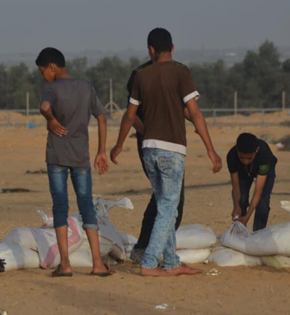 Palestinian youths making sandbags east of Rafah in preparation for the violent activities on Friday, May 4, 2018 (PALINFO Twitter account, May 4, 2018)