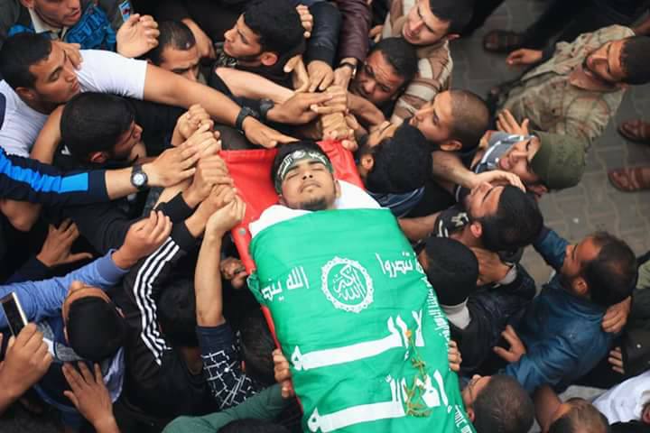 Photos of Bahaa Qudeih’s funeral. His body is wrapped in a Hamas flag and operatives of the military wing are beside him (Facebook page of the Qudeih family, May 6, 2018)