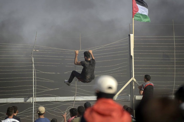 بعض الفلسطينيين يحاولون عبور الجدار الأمني شرقي مدينة غزة (صفحة 