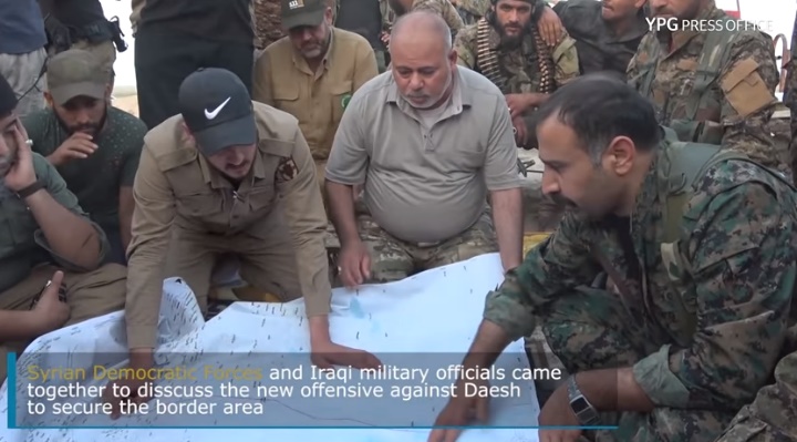 Commandants des FDS avec des commandants irakiens dans la zone du terminal de Tell Safouk. Les parties discutent d'une nouvelle attaque visant à nettoyer la zone frontalière entre la Syrie et l'Irak de la présence des membres de l'Etat islamique (Chaîne Youtube du YPG Press Office, 22 juin 2018)