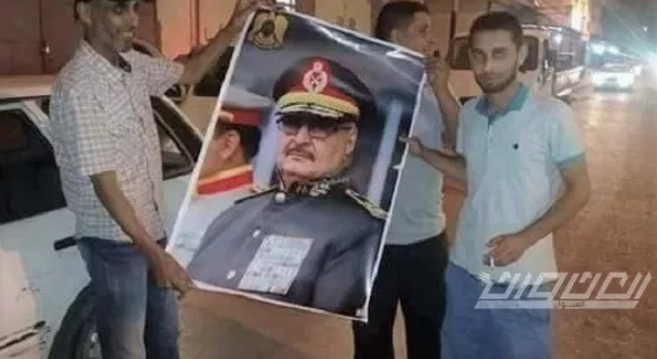 Des civils dans la ville de Derna célèbrent la reprise de la ville par l'armée, arborant des photos du général Haftar (Al-Unwan, Libye, 25 juin 2018)