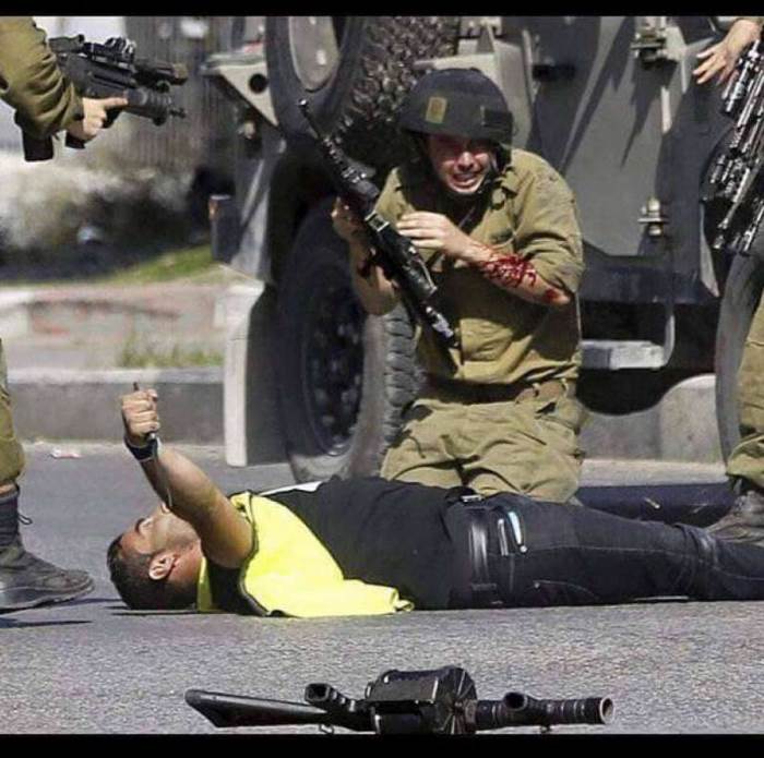 A wounded IDF soldier. The terrorist is still holding the knife he used to stab him (Khabar News Agency, October 16, 2018).