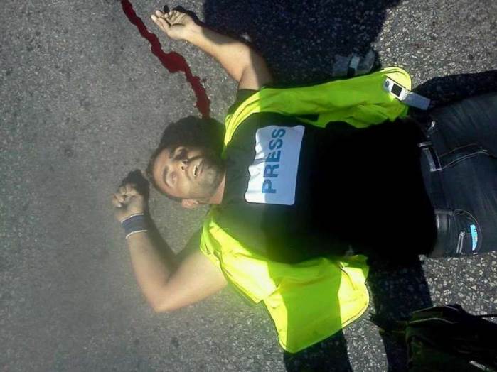 Terrorist Iyad al-'Awauda, killed during a stabbing attack on an IDF soldier in the Hebron region. He was wearing a yellow vest and a Press T-shirt.