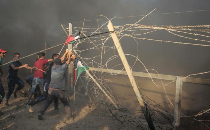 Gazan rioters try to break through the security fence during a 