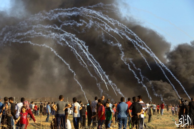 Gazans burn tires near the security fence.