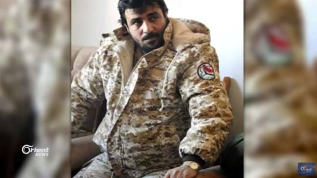 Local commander of the National Defense Forces, codenamed Firas al-Iraqi, detained by the Shiite militias in Albukamal (Orient News YouTube channel, August 19, 2018). The insignia of the National Defense Forces can be seen on his sleeve (right).