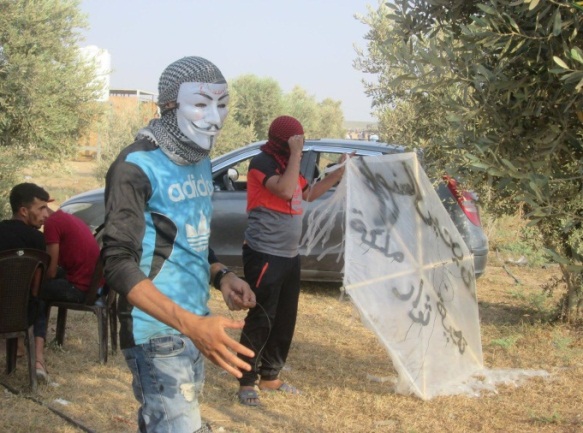 Opérateurs de l'unité de lancer de ballons "Fils d'al-Zouari" dans l'Est de la ville de Gaza. En arabe sur le cerf-volant on peut lire: "A Yahya al-Sinwar, salutations des révolutionnaires Malaka" [Malaka est le nom d'un poste militaire palestinien dans l'Est de la ville de Gaza] (Page Facebook de l'autorité nationale suprême de la marche du retour, 31 août 2018)