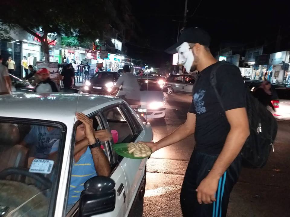 Masked Gazan hands out cookies after the attack (QudsN Twitter account, October 7, 2018). Palestinian Tweets after the attack.