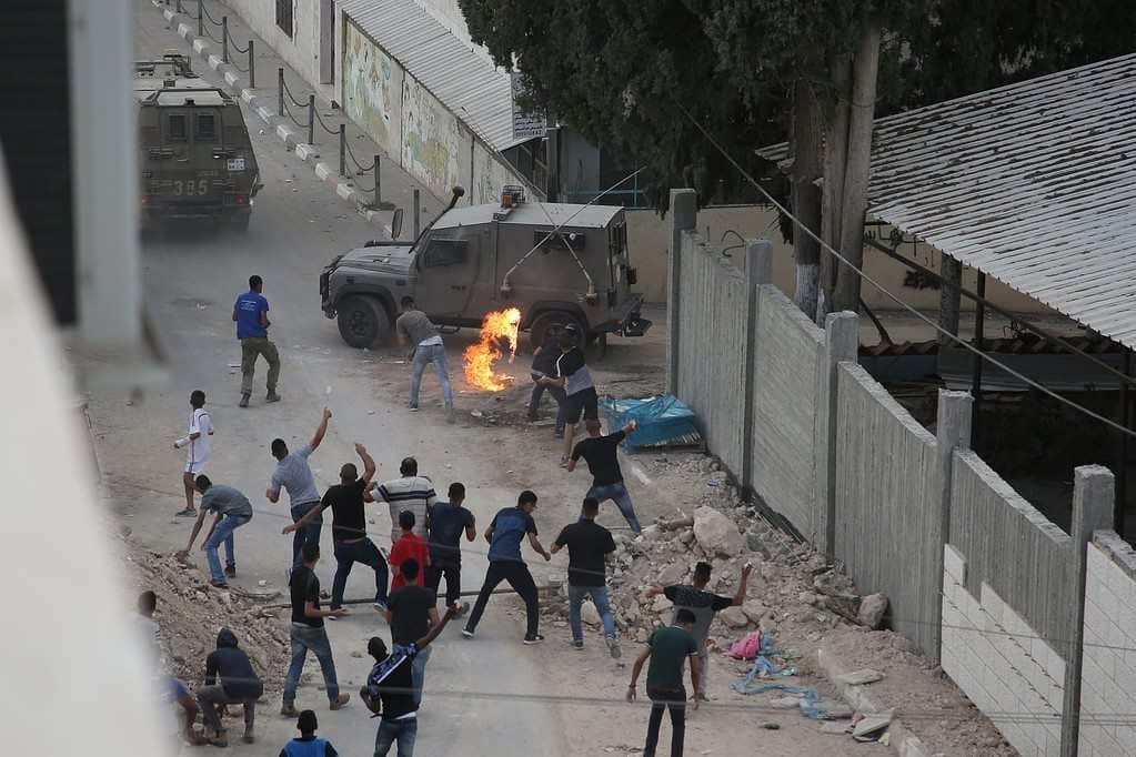 palestinos atacando con piedras y bombas incendiarias a las fuerzas de seguridad israelíes durante la actividad en la aldea Shuweika donde vivía el atacante (cuenta de PALINFO en Twitter, 7 de octubre de 2018).