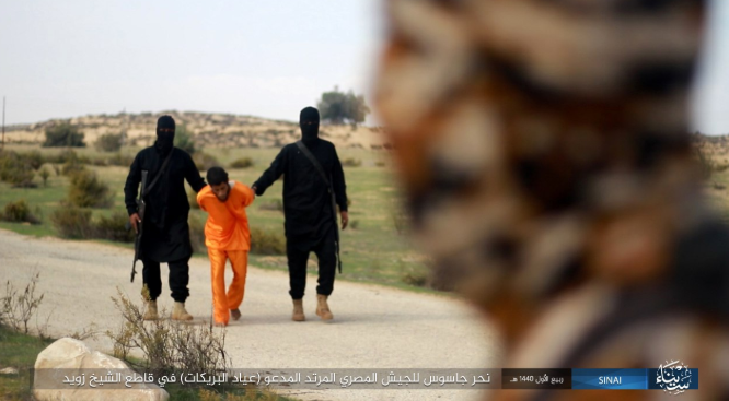 Ayyad al-Breikat wearing an orange jumpsuit, led by two ISIS operatives to the site of his execution (Shumukh, November 26, 2018)