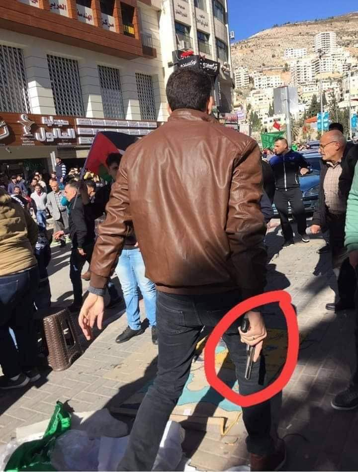 Operative in one of the PA's security services wearing civilian clothes and carrying a gun during the dispersal of the parade in Nablus (Twitter account of the Amama website, December 14, 2018).