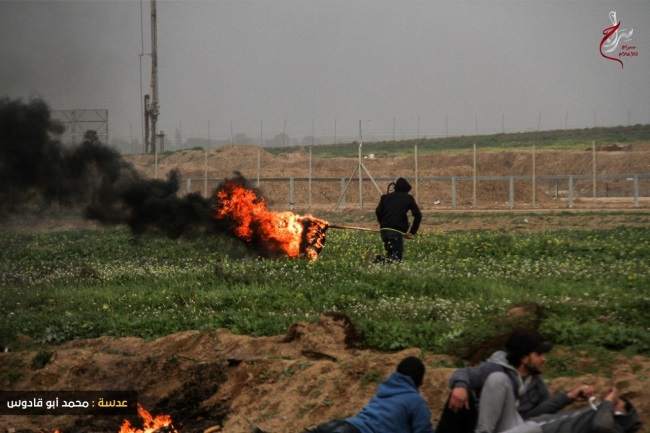 Des manifestants de la "marche du retour" brûlent des pneus et un drapeau israélien à Gaza (Page Facebook de l'Autorité nationale de la marche du retour, 15 février 2019)