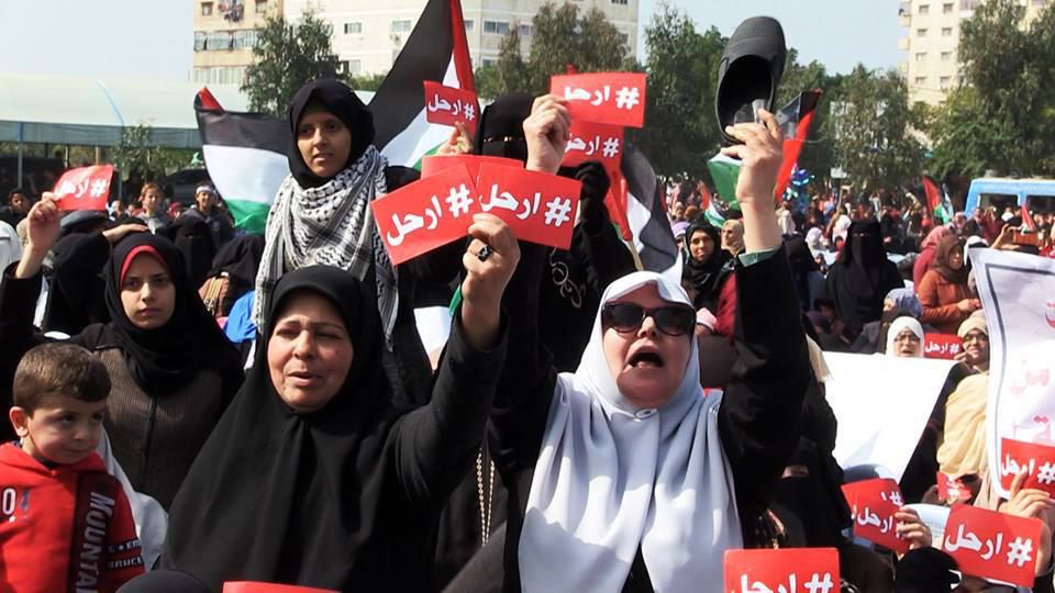 Protesters in Gaza wave signs calling for the resignation of Mahmoud Abbas.