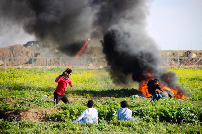 Incendie de pneus et lancer de pierres près de la barrière de sécurité (Page Facebook de l'Autorité nationale de la marche du retour, 22 mars 2019)