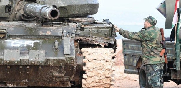 Syrian army soldier near a tank, preparing for the campaign over Idlib (Butulat Al-Jaysh Al-Suri, February 21, 2019).