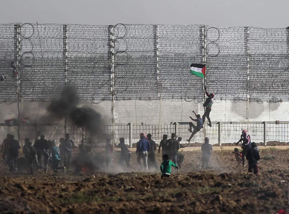 Des émeutiers escaladent la barrière frontalière à l'Est de la ville de Gaza (Page Facebook de l'autorité nationale de la marche du retour, 22 mars 2019)