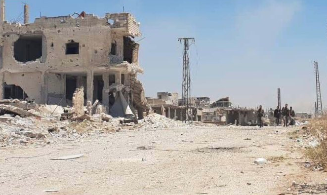 Soldiers of the Syrian army and the forces supporting it patrolling in the ruins of Kafr Nabudah.