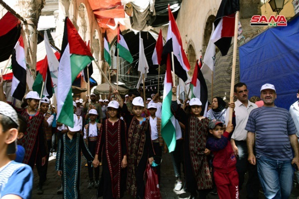 Jerusalem Day marchers in Damascus wave Palestinian and Syrian flags. 