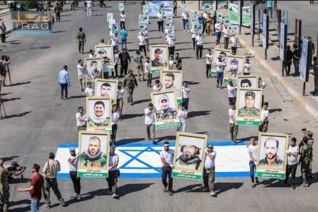 Jerusalem Day marchers carry pictures of shaheeds, and walk on an Israeli flag pained on the road (Yes Iraq website, May 31, 2019).