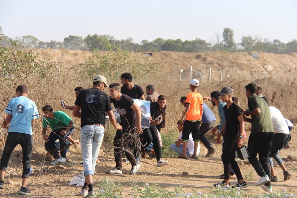 Palestinian rioters pull at the barbed wire fence near the security fence in the eastern part of the al-Bureij refugee camp (Supreme National Authority of the Great Return March Facebook page, June 21, 2019).