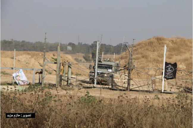 תמונה מסרטון המתעד מפגינים פלסטינים חוצים את גדר הביטחון על הגדר נראים תמונה של נשיא מצרים לשעבר, מחמד מרסי, ודגל של ועדות ההתנגדות (דף הפייסבוק של הצלם חאזם מזיד, 21 ביוני 2019). 