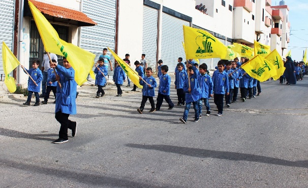 Students of the Al-Mahdi school in Al-Qatrani waving Hezbollah flags and holding photos of shahids as part of the Shahid Day events (Facebook page of Fatima Baalbaki, November 15, 2016)