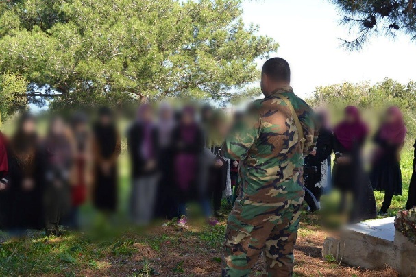 Armed Hezbollah fighter talking to female student members of the Nour Club, an Education Mobilization student cell at LIU (Lebanese International University). The talk took place during a trip organized by the Education Mobilization to the village of Naqoura in southern Lebanon.