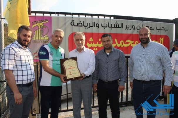 Minister of Youth and Sports Muhammad Fneish (center) receives a plaque of appreciation from the Sports Mobilization in the Al-Zahrani sector at the opening ceremony of the Sports Mobilization’s summer activities (Al-Saksakiyeh website, June 2019)