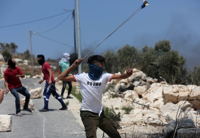 Palestinians throw stones at the Israeli security forces during the weekly riots in Kafr Qaddum (Wafa, July 26, 2019).