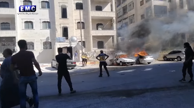 The car of Abu Khaled the Engineer (a white car on the left) on fire after the detonation of the IED (Rebel-affiliated Facebook page Edlib Media Center, August 22, 2019)