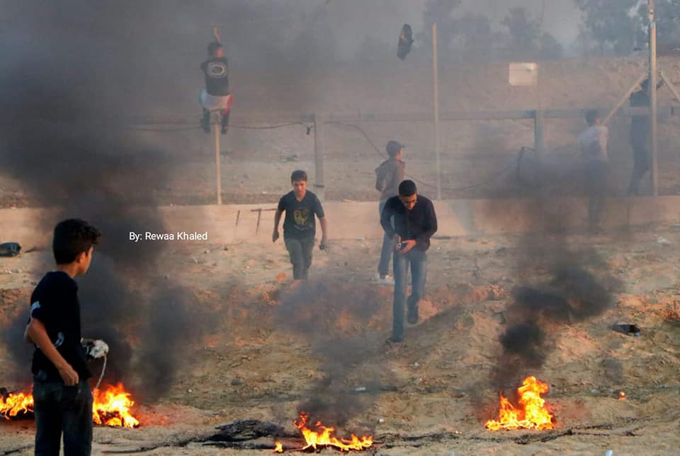 Palestinian rioters climb on the security fence and burn tires in eastern Rafah (Supreme National Authority Facebook page, November 1, 2019).